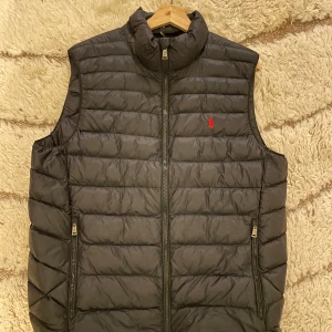 Ralph Lauren väst  - Säljer en svart Ralph Lauren väst. Den är sparsamt använd och i mycket bra skick. Storlek M. Mitt pris 1999kr, nypris 3299kr. Hör av er för fler bilder eller vid funderingar!