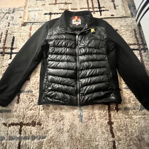 Svart jacka från Parajumpers - Snygg svart jacka från Parajumpers med quiltad framsida och dragkedja. Jackan har långa ärmar och en cool patch på ärmen. Perfekt för kyligare dagar.