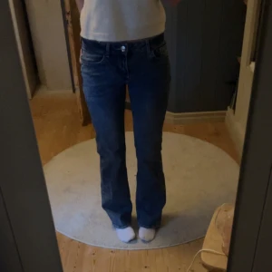 Blå bootcut jeans - Säljer ett par blå bootcut jeans med låg midja. De har en dragkedja och knapp framtill. Säljer då dom inte används och är lite långa för mig som är ca 162💗