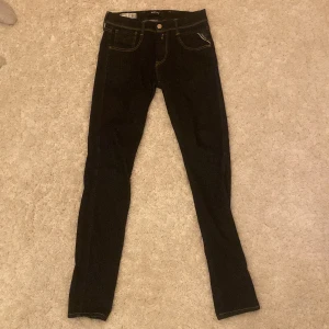 Svarta jeansbyxor från Replay - Snygga svarta jeansbyxor från Replay i modellen Anbass. De har en slim fit passform och klassisk femficksdesign med dragkedja. Perfekta för en stilren look.
