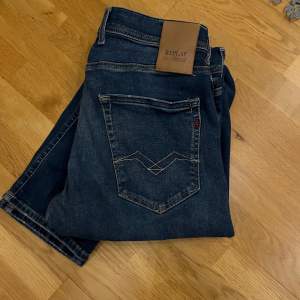 Snygga mörkblå jeans från Replay Hyperflex med klassisk femficksdesign. De har en bekväm passform och är perfekta för en avslappnad stil. Märkeslogga på bakfickan och läderdetalj vid midjan.