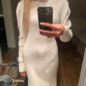 Vit ribbad stickad långklänning - Snygg vit ribbad långklänning med långärmad design. Super skön och i fint skick! 