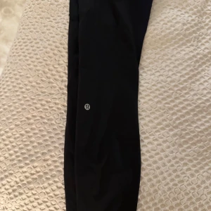 Svarta leggings från Lululemon - Snygga svarta leggings från Lululemon, perfekta för träning. De är högmidjade och har en tight passform som ger bra stöd. Materialet är mjukt och stretchigt för maximal komfort. har fickor 