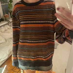Mönstrad ulltröja från Tommy Hilfiger - Säljer en mysig Tommy Hilfiger tröja med ett färgglatt mönster i orange, blått och svart. Den är oversize och har långa ärmar och en rund halsringning, perfekt för vinter! 