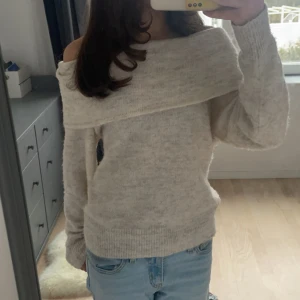 Beige stickad offshoulder-tröja - Mysig beige stickad tröja med offshoulder-design. Perfekt för kyliga dagar med sin mjuka och bekväma passform. Tröjans etikett är tyvärr borta.💕