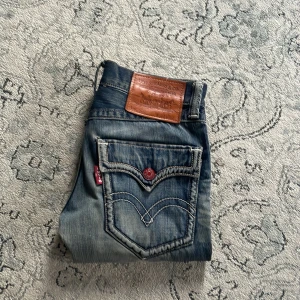 Vintage Levis 502  - Vintage Levis 502 gjorda över 30 år sedan! Straight fit med slitningar och en riktigt snygg tvätt. Midja ungefär 40cm, benöppningen 21. De har fickor med knappar vilket som är rätt så sällsynt på Levis,  L32 W32 true to size. Mina favoriter av en anledning.  Kom med frågor eller fler bilder.