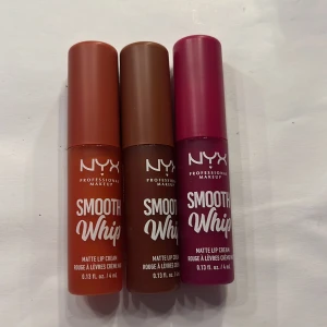NYX Smooth Whip Matte Lip Cream - HELT NYA OCH INTE TESTADE!!!! Säljer tre NYX Smooth Whip Matte Lip Cream i olika nyanser: en varm orange, en djup brun och en livlig rosa. Dessa läppkrämer ger en matt finish och kommer i en smidig applikator för enkel applicering. Perfekt för att ge läpparna en färgstark look.