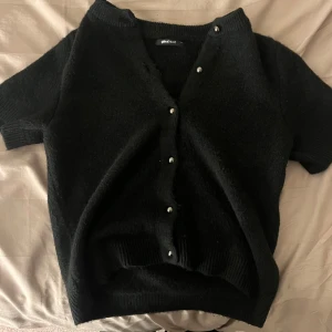 Kortärmad kofta - Fin stickad och kortärmad kofta från gina med knappar på. Mycket bra skick!