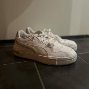 Vita sneakers från Puma - Säljer ett par stilrena vita sneakers från Puma. Använt skorna ett fåtal gånger, nästan nyskick. 