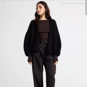 Svart kofta från Lindex - Mysig svart kofta från Lindex i en fluffig och mjuk design. Koftan har en öppen front och långa ärmar, perfekt för kyliga dagar. Enkel att matcha med olika outfits. Och är super mysig, helt ny och inte nopprig eller tecken på användningen. Lapp sitter ej kvar, därför kan jag inte lämna tillbaka. Storlek M/L, nypris 899kr. Pris diskuteras OBS DETTA ÄR EJ SAMMA SOM BEIGE SOM SÄLJS FÖR 399kr denna har mer kvalité och säljs för 899kr (bild 4)