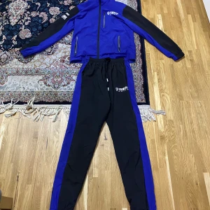 Blå och svart träningsjacka från Yamaha - Snygg blå och svart träningsjacka från Yamaha Racing med dragkedja och logga på bröstet. Perfekt för sportiga aktiviteter och har en bekväm passform.