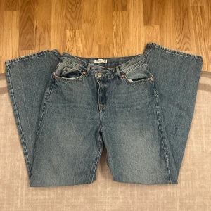 Blå jeans från Pull&Bear - Säljer ett par klassiska blå jeans från Pull&Bear. De har en straight passform och är tillverkade i denim. Perfekta för en avslappnad stil. Jeansen har en V design på framsidan