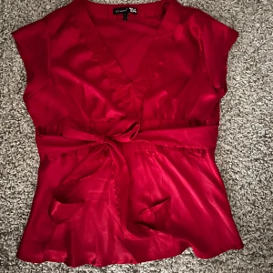 Röd satinblus med knytband - Elegant röd blus i satin, perfekt nu till jul men även till fest😍😍 bandet går att knyta både bak och fram!!