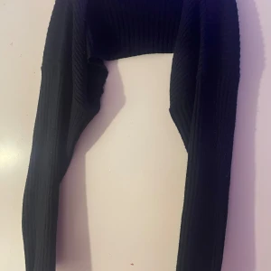 Svart bolerotopp från Shein - Säljer en svart bolerotopp från Shein. Den är ribbad och har långa ärmar, perfekt för att lägga till en extra touch till din outfit. Passar bra till både vardag och speciella tillfällen.