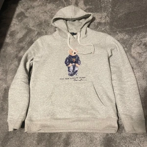 Grå hoodie från Ralph Lauren - Säljer en grå hoodie från Ralph Lauren. Tröjan är Strlk M. Skick 8/10, använd få tal gånger. Hör av er vid minsta lilla fundering.