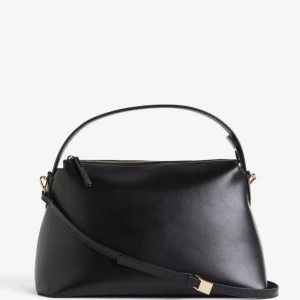 Svart axelväska med dragkedja -  Väskan har en justerbar axelrem, är oanvänd och har kvar prislappen. 