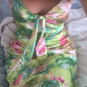 Somrig klänning - Mönstrad klänning i glansigt tyg, ungefär knälängd. Lite sydd uppe vid ena bröstet men märks knappt då det smälter in i mönstret 💚🌺kan mötas upp i Stockholm och Södertälje.