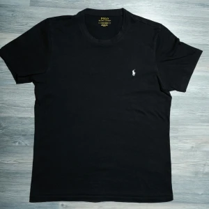 Svart Ralph Lauren T-Shirt  - Säljer nu denna riktigt snygga Ralph Lauren t-shirten. Väldigt fint skick, inga defekter. Storlek S. Nypris ca 699, mitt pris endast 325kr. Hör av dig om du undrar något eller vill ha fler bilder! Pris är diskuterbart vid snabb affär🤝