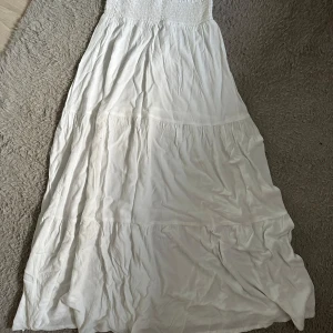 Vit långkjol från Lager 157!❤️ - Säljer en vacker vit långkjol från Lager 157. Kjolen har en elastisk midja och är i ett luftigt material, perfekt för varma dagar. Den har en flödande design med flera lager som ger en fin volym. Passar utmärkt för en avslappnad och stilren look. den är liten genomskinlig. Säljer den för att den inte kommer till användning!🩷