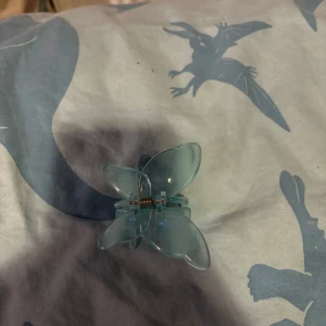 Blå fjärilsformad hårklämma - Söt och stilren hårklämma i form av en fjäril. Den är ljusblå och perfekt för att hålla håret på plats med stil. Klämman har en enkel och elegant design som passar till många olika tillfällen.
