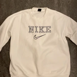 Vit vintage sweatshirt från Nike - Säljer en klassisk vit sweatshirt från Nike. Den har en stor Nike-logga på framsidan och är i storlek L, Passar även till M. Perfekt för en avslappnad stil och passar till nästan allt. Tröjan är i bra skick och superbekväm! Nytvättad 