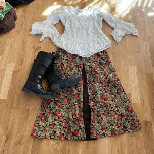 Höstkjol med frukter🍇🍒🍎 - Jätte fin höstkjol som jag köpt hoss popp uppen Vinokilo🫶🏻 Har inget märke i men ser ut som en hemma syddkjol💕 Lite för stor för mig som är en 36, sitter mer lågmidjat på mig.