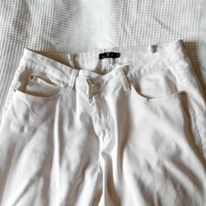 Byxor, vita - Svagt ormskinsmönster, stl 44, ngt korta ben. Hundar finns i hemmet.