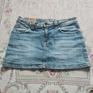 Minikjol - Söt minikjol med fina detaljer och fickor. Har även två andra kjolar på min sida Midjemått: 36 Längd: 31