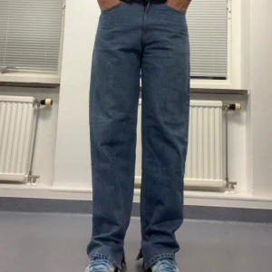 Blåa Levi’s jeans - Blåa vintage Levi’s 550 jeans med slits längst ner på benen. Dessa jeans är också omsydda av beyond retro storlek 36/43