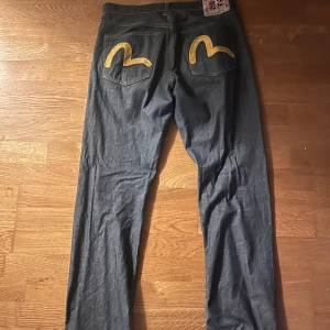EVISU JEANS - Säljer mina VINTAGE ÄKTA EVISU JEANS❗️ evisu jeans säljs för mellan 3-7 tusen kr men jag säljer dessa för 2100 kr , kan diskuteras strl 32.  Skriv för fler bilder  Väldigt bra skicka förutom att det är nött längst ner på benet (SKRIV FÖR BILD ❗️❗️)