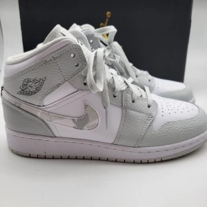 Nike Air Jordans i vitt och grått - Snygga Nike Air Jordans i vitt och grått. De har en klassisk design med snörning och den ikoniska loggan på sidan. Perfekta för både vardag och fest. Skorna är i mycket bra skick och redo att användas direkt. Passar perfekt till streetwear-stilen!