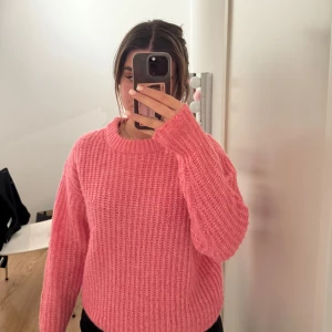 Rosa stickad tröja från H&M - Säljer en supermysig rosa stickad tröja som är perfekt för kyliga dagar. Den har en normal passform och långa ärmar, vilket gör den idealisk för både höst och vinter. Tröjan är i mycket bra skick och passar perfekt till jeans eller kjol för en avslappnad look. Perfekt för dig som älskar att hålla det enkelt men stilrent! 💖