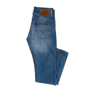 Levi's 512 jeans i blå denim - Säljer ett par klassiska Levi's 512 jeans i blå denim. De har en snygg, något blekt look. Jeansen passar till alla tillfällen och går att kombinera med många överdelar och skor!