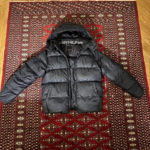 Vinterjacka från Tommy Hilfiger - Säljer en svart pufferjacka från Tommy Hilfiger i mycket bra skick. Jackan är perfekt för vintern med sin varma och quiltade design. Modellen på bilden är 173cm lång och väger 73kg. Jacka passar som XS. Nypris ligger på runt 1899kr och här kan den köpas för bara 899kr. Vid fler frågor är det bara att skriva.