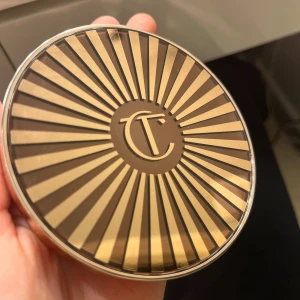 Beautiful Skin Sun-Kissed Glow Bronzer - Säljer en lyxig bronzer från Charlotte Tilbury i nyansen 'Medium'. Den ger en solkysst glöd och har en krämig konsistens som smälter in i huden för en naturlig look. Perfekt för att skapa en hälsosam lyster året runt! Använd fåtal gånger så mycket kvar!