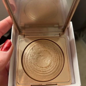 CAIA highlighter  - Säljer en fantastisk gyllene highlighter med skimrande finish. Perfekt för att ge ansiktet en strålande glöd. Kommer i en praktisk kompakt förpackning med spegel, vilket gör den lätt att ta med sig. Perfekt för både vardag och fest! Använd som syns men mycket kvar!