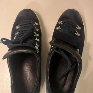 Marostica Low Navy Suede Sneakers - Säljer ett par snygga Marostica Low sneakers från Diemme i marinblå mocka. Skorna har en stilren design med snörning och silverfärgade detaljer. Perfekta för både vardag och festliga tillfällen. De är i mycket bra skick och redo för nya äventyr! Säljer dessutom för att dem inte passar och har använt dem fåtala gånger dem är bara smutsiga. Tvättar såklart innan dessa fraktas och dem kommer se ut som nya. box ingår och vid frågar skriv i dm.     Köpta för ca 3699kr