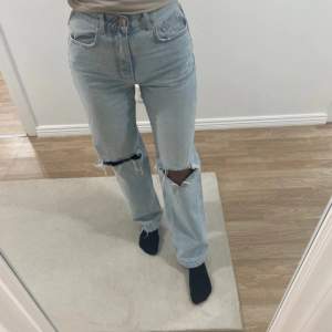 Säljer ett par ljusa jeans från Gina tricot, perfect Jeans i storlek 34. De har en hög midja och är i straight fit. Jeansen har coola slitningar på knäna som ger en avslappnad look. Perfekta för både vardag och fest! 🕺