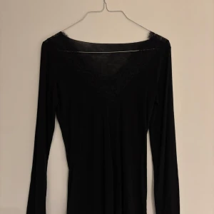 Intimissimi svart  - Säljer en elegant svart långärmad topp från Intimissimi. Den har fina spetsdetaljer vid halsringningen som ger en lyxig känsla. Perfekt för både vardag och fest. Toppen är i mycket bra skick och passar perfekt till höst- och vintergarderoben. Den är knappast använd ( max 1-4 gånger ) pris kan diskuteras 