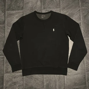 Ralph lauren sweatshirt - Svart Ralph lauren sweatshirt i toppskick ! 🤠 Otroligt skönt material så mycket bekväm att använda, men även stilren ! 👊 Som ni ser på bilderna har texten vid nacken nöts bort lite, inget som syns vid användning förstås 🙌 Bara att höra av sig vid frågor ! 🌟