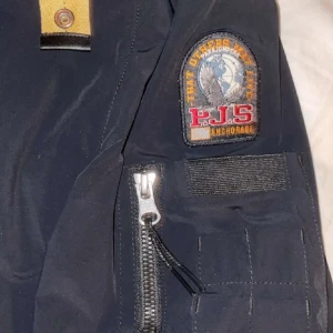 Para jumper windbreaker - Säljer en svart jacka från parajumper i storlek M, Perfekt för höst och vår med sin stiliga design och praktiska fickor. Jackan är i bra skick och har inga fläckar eller skado, pris kan sänkas för snabb affär.