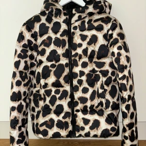 Leopardmönstrad pufferjacka från Pieces - Säljer en leopardmönstrad pufferjacka från Pieces. Jackan har en dragkedja framtill och en huva. Perfekt för att hålla sig varm och snygg under höst och vinter 🐆✨i jättefint skick! 