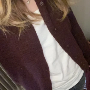 Mörklila kofta - Säljer en mysig vinröd tröja den är tyvärr för stor för mig i armarna. Jag köpte den från HM för 300 kr och har ändats andvänt den 2 gånger.  