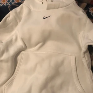 Vit hoodie från Nike - Säljer en stilren vit hoodie från Nike. Den har en klassisk design med en liten Nike-logga på bröstet och en stor ficka framtill. Perfekt för både vardag och träning. Superbekväm och passar till allt! 🏃‍♂️