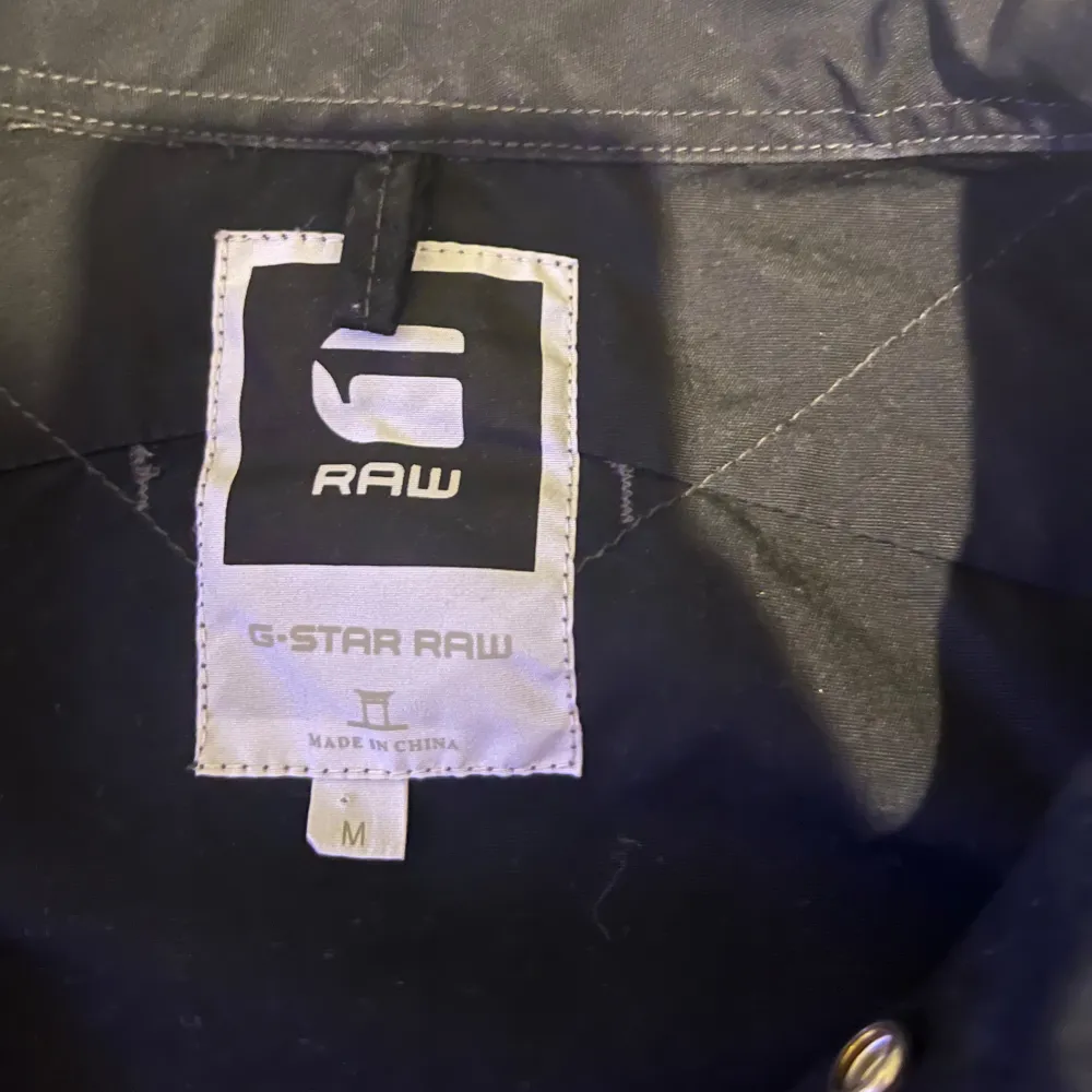 Säljer en snygg svart jacka från G-Star RAW i storlek M. Den har en klassisk design med knappar framtill och långa ärmar. Perfekt för höst och vår, och funkar både till vardags och fest. Jackan är i mycket bra skick och redo för nya äventyr!. Jackor.