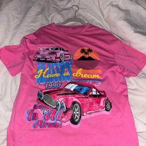 Rosa t-shirt med biltryck - Cool rosa t-shirt med färgglatt tryck av bilar och texten 'Have a dream 1990 Believe in all miracles'.  Aldrig använd bara provat så helt ny! Strl xs men skulle även passa i s💕