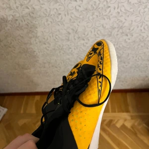 Nike futsal skor  - Säljer ett par coola Nike fotbollsskor i gult och svart med snyggt mönster. Skorna har en vit sula med limegröna detaljer och svart snörning. Perfekta för inomhusfotboll eller träning. De är i bra skick och redo för nya äventyr på planen!, hör av er vid frågor eller likande!