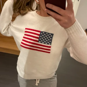 Vit stickad tröja med amerikansk flagga - Säljer en superfin vit stickad tröja som är perfekt nu i vinter.  Tröjan är sjuukt mjuk🧸Skick 8/10- lite små noppor men inget som syns så mycket. Storlek XS men passar mer som S/M💕❄️❄️//Skriv om du har frågor😊