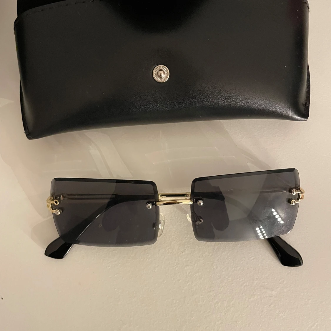 Svarta rektangulära solglasögon med gulddetaljer - 92
