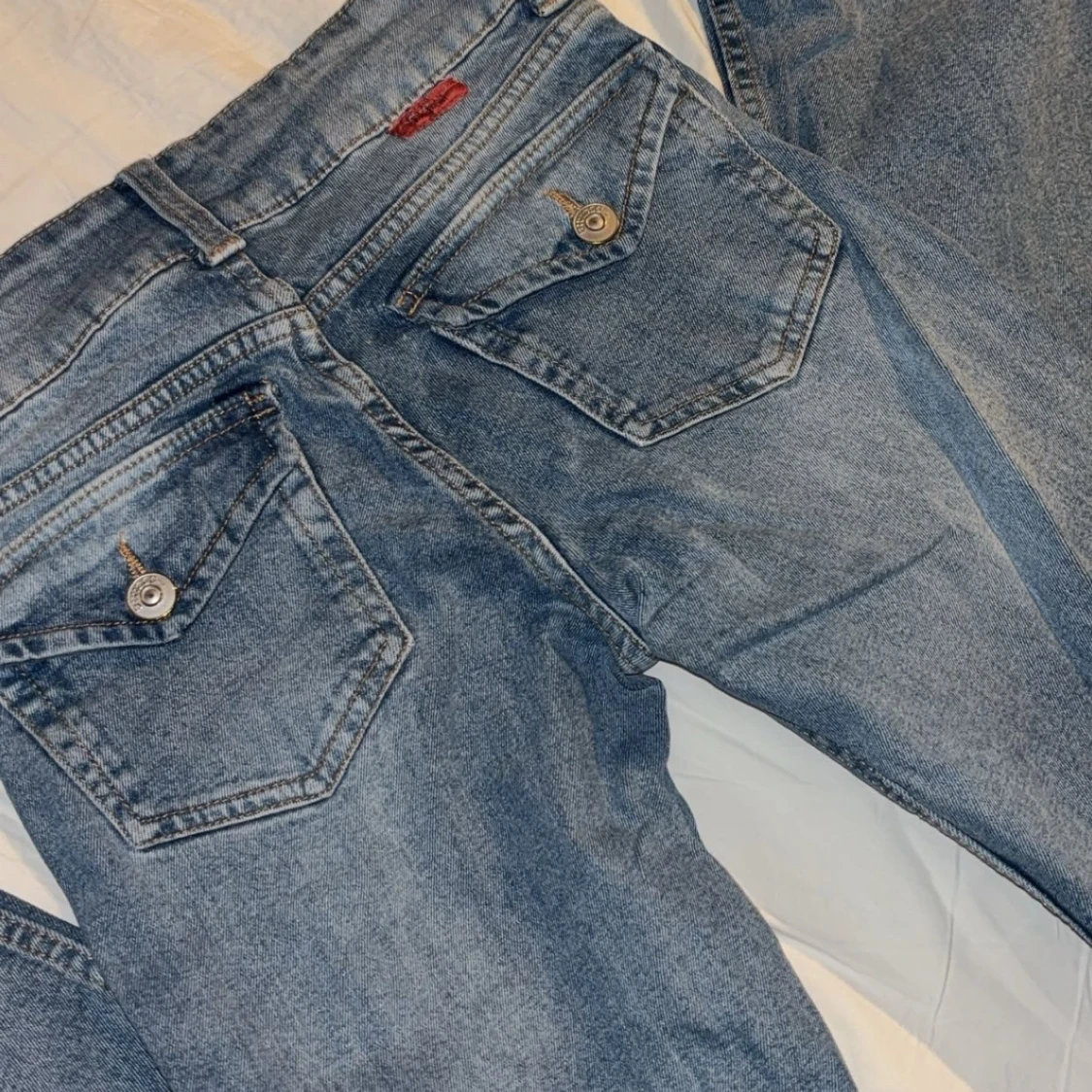 Blåa lågmidjade jeans med fickor på baksidan